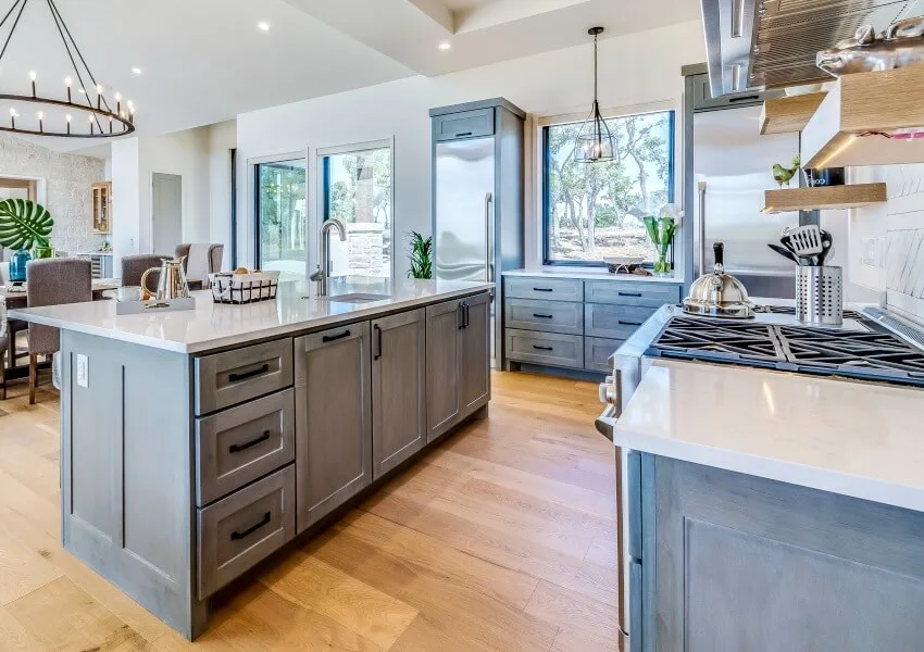 Natural wood flooring and gray pre-assembled shaker cabinetry in new kitchen