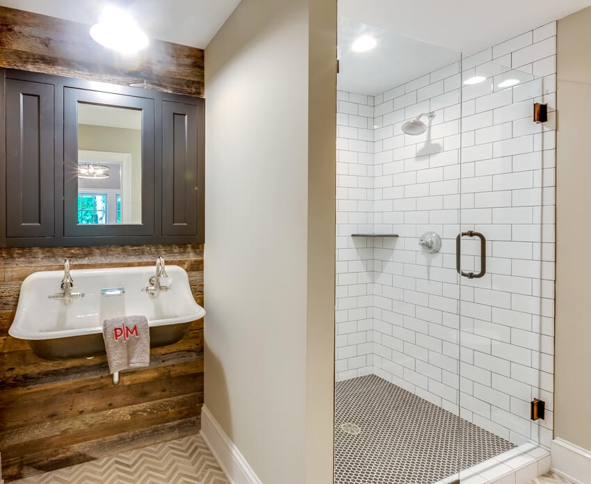 Bathroom with wall mounted sink, white wall subway tile in shower with dark penny tile flooring