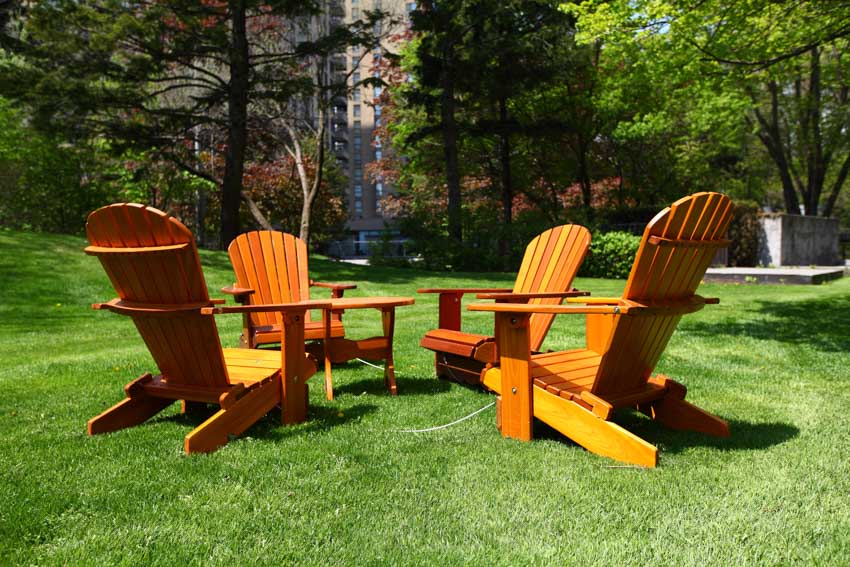 Outdoor area with four wooden Muskoka chairs arranged in a circle