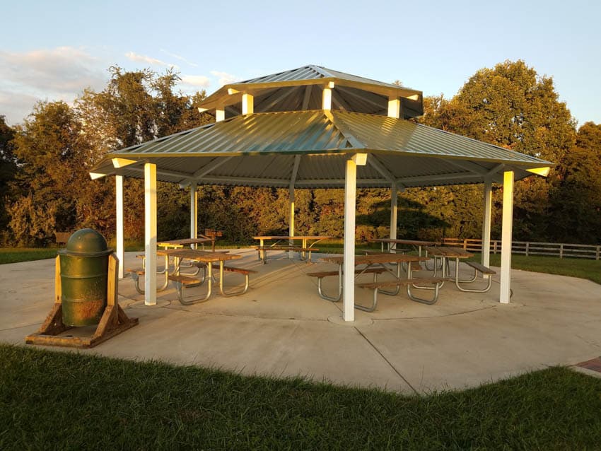 Outdoor area with paved concrete grounds, chairs, pavilion, and metal roof