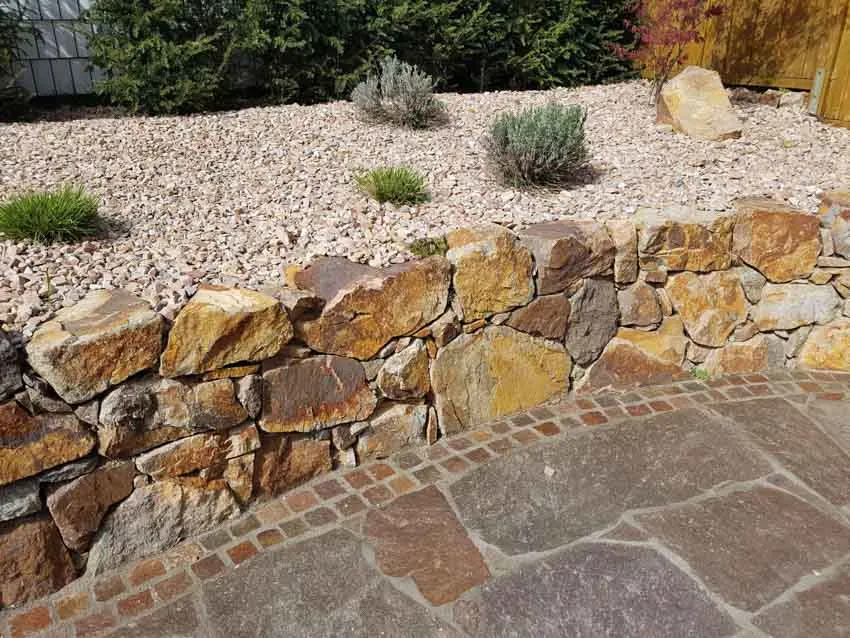 Outdoor area with raised stone garden and paver with stone border