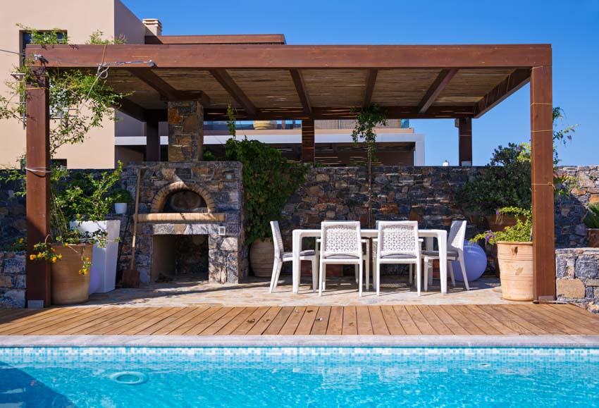 Covered patio with oven, outdoor furniture and swimming pool