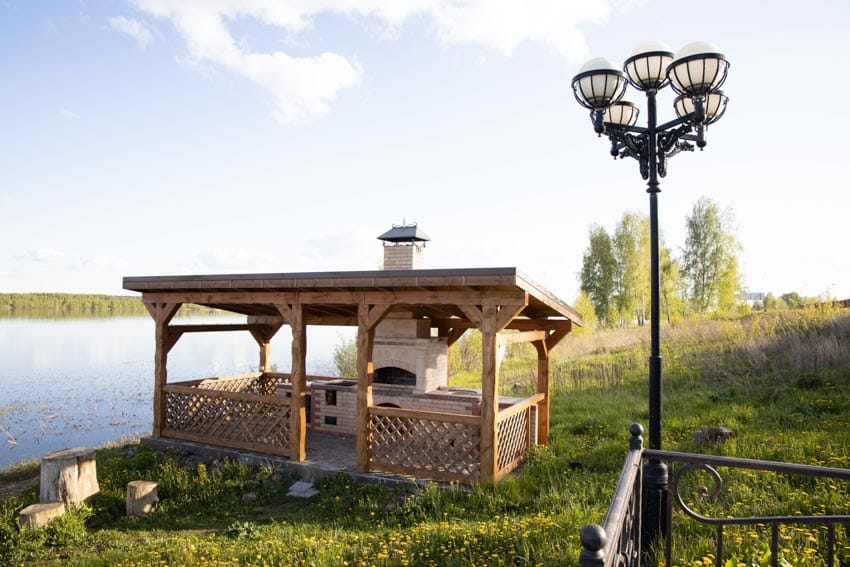 Outdoor fireplace with pizza oven, chimney, pergola, and roofing