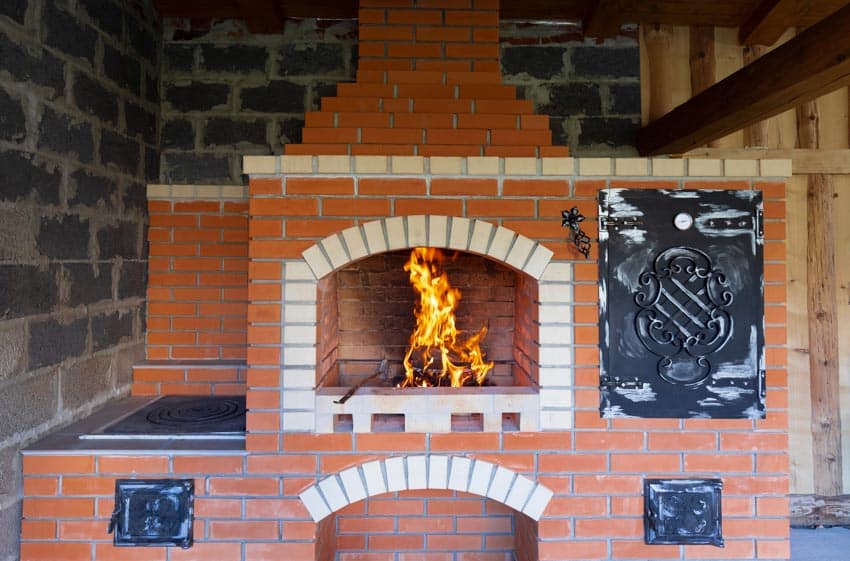Outdoor fireplace with pizza oven made of orange bricks