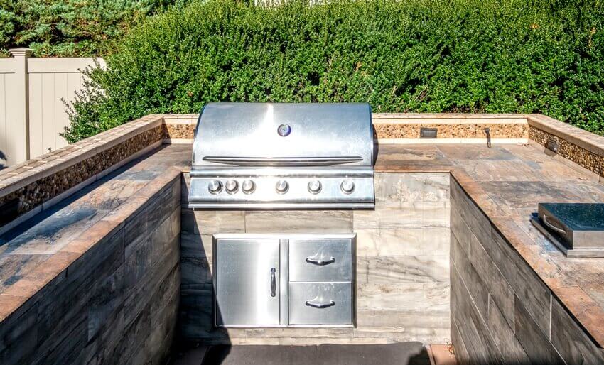 Outdoor kitchen with flagstone countertop and stainless appliances