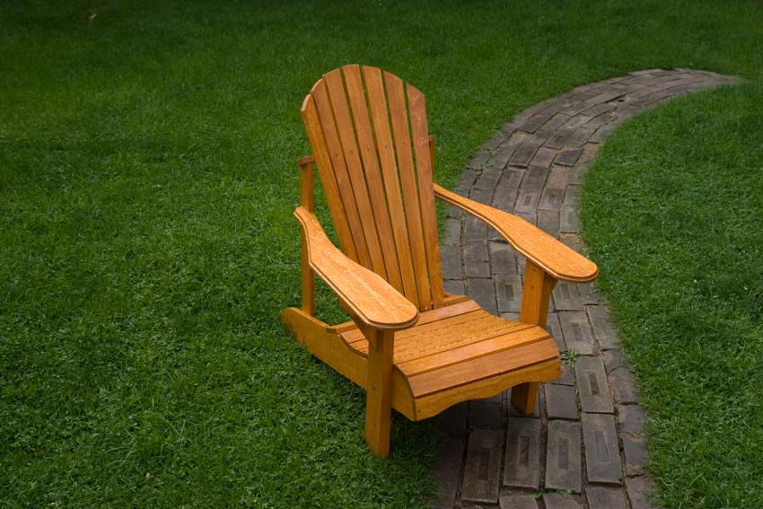 Outdoor lawn with brick walkway, grassy area, and a wood Muskoka chair