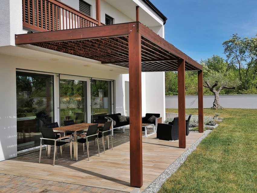 Outdoor patio with canopy roofing, table, chairs, and glass door