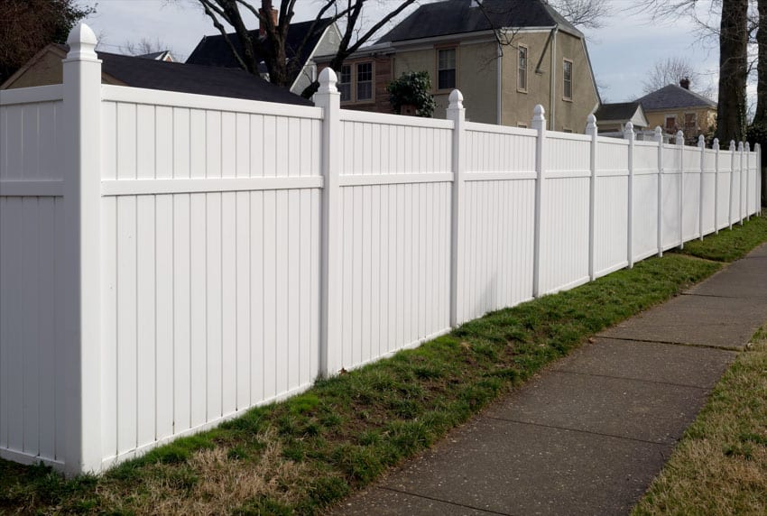 Residential property enclosed within a white vinyl fences