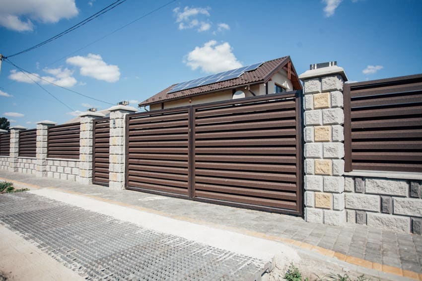 Residential property with horizontal fence panels, and stone pillars