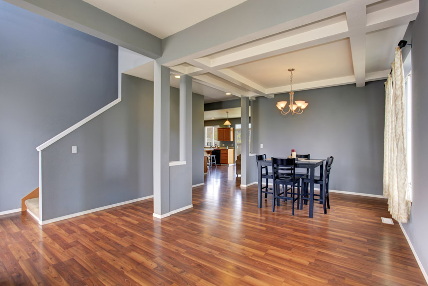 Room with grey walls, wood flooring, chandelier and dining set