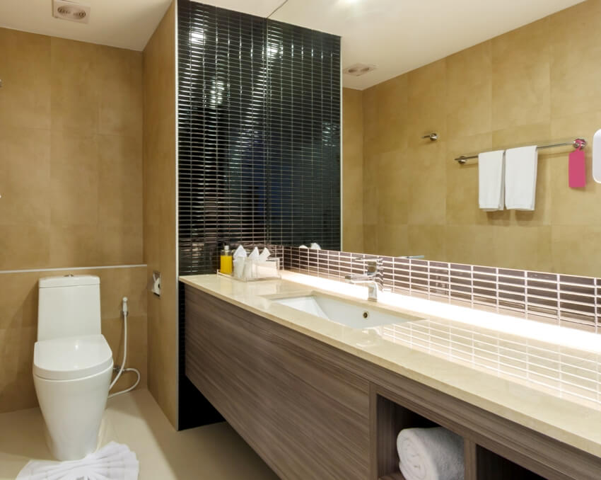 Simple bathroom interior with tile overlay laminate countertop and a toilet