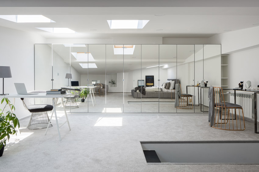 Spacious home office with mirror wall panels, desks and chairs