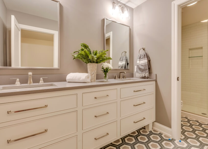 Stunning bathroom interior with painted laminate countertop, vanity mirrors and patterned tile flooring