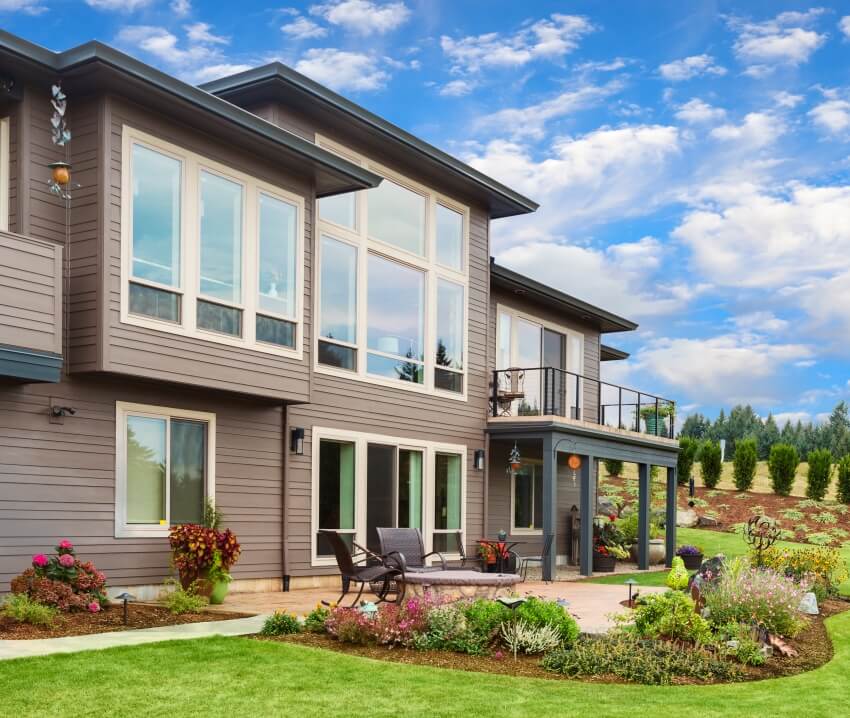 Front of a home with beautiful landscape and tinted windows