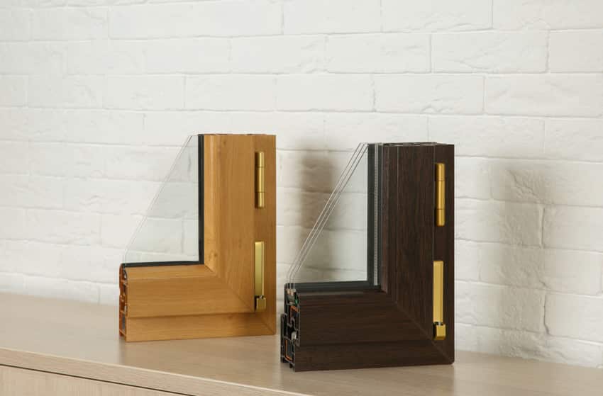 Two cutout wood frames containing triple glass panes for windows