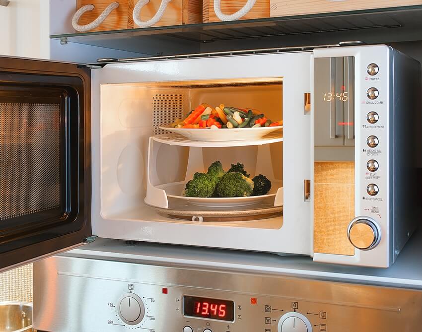 A two tier microwave with tray enables heating two plates at once