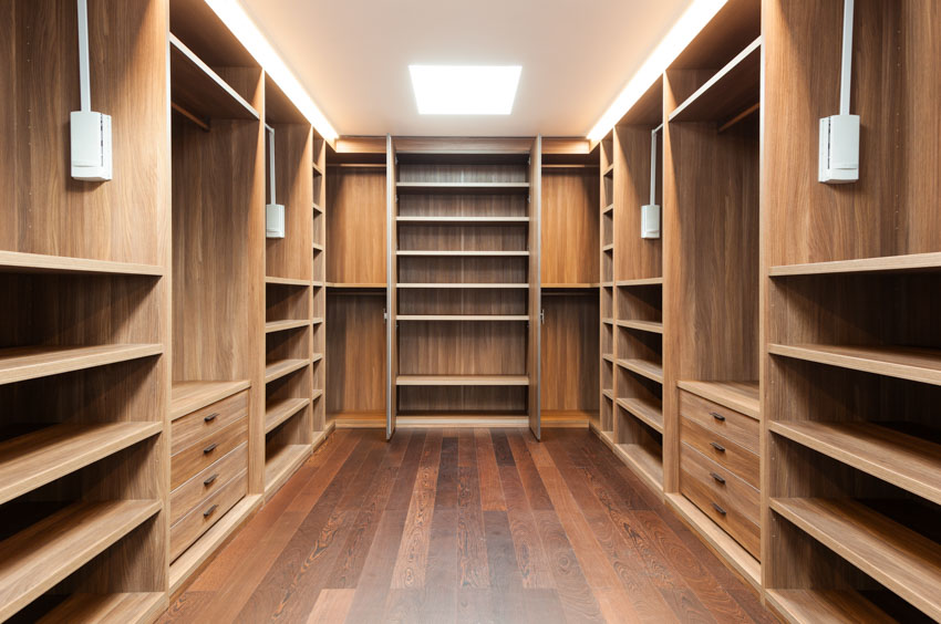Walk-in cedar closet with wood floors, shelves, and drawers
