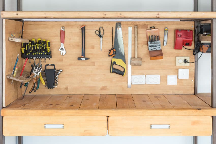 Wooden workbench with plywood backsplash, drawers, and tools