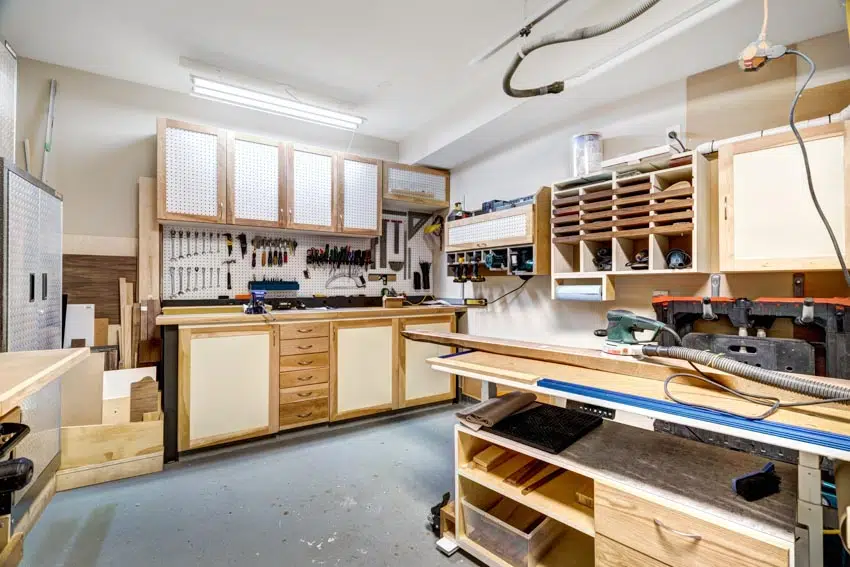 Workspace with cabinets, workbench, countertop, drawers, and pegboard as a backsplash