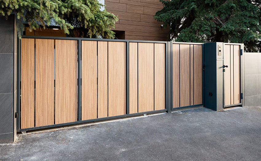 Modern wood gate with powder coated metal frame and side door entry