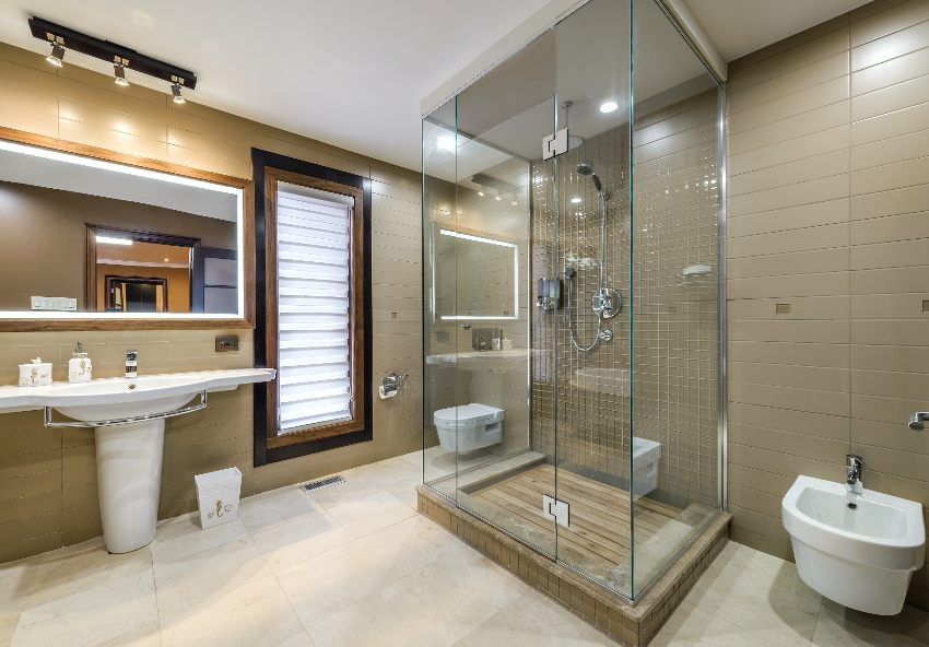 Amazing bathroom with tiled flooring, pedestal sink, toilet, shiplap walls and shower enclosed with glass and ceiling tiles