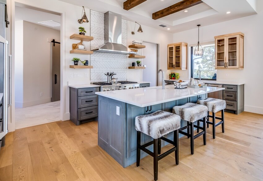 Modern farmhouse style kitchen with blue distressed wood island, open shelving, and beam ceiling