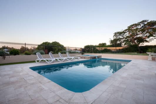 Gunite Pool Pros And Cons Colors Finishes   Backyard Gunite Pool With Lounge Chairs Plants And Fence Is 531x354 