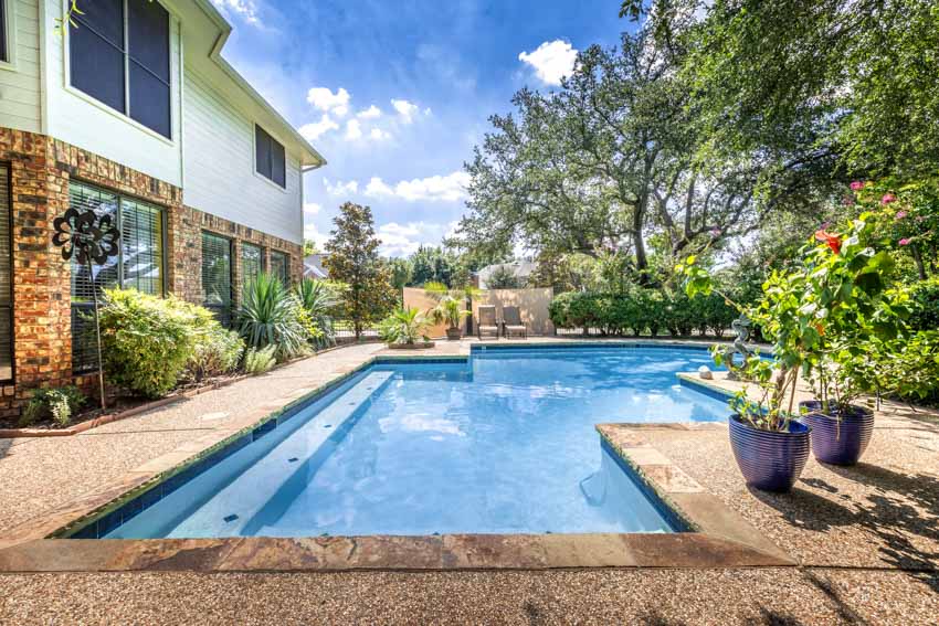 Backyard gunite pool with plants, and epoxy deck