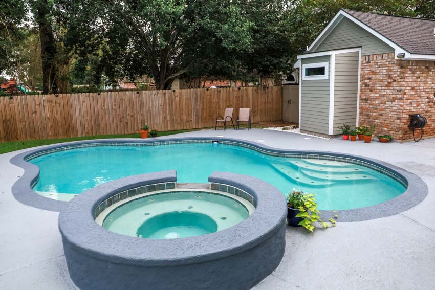 Backyard with gunite pool, hot tub, shed, and wood fence