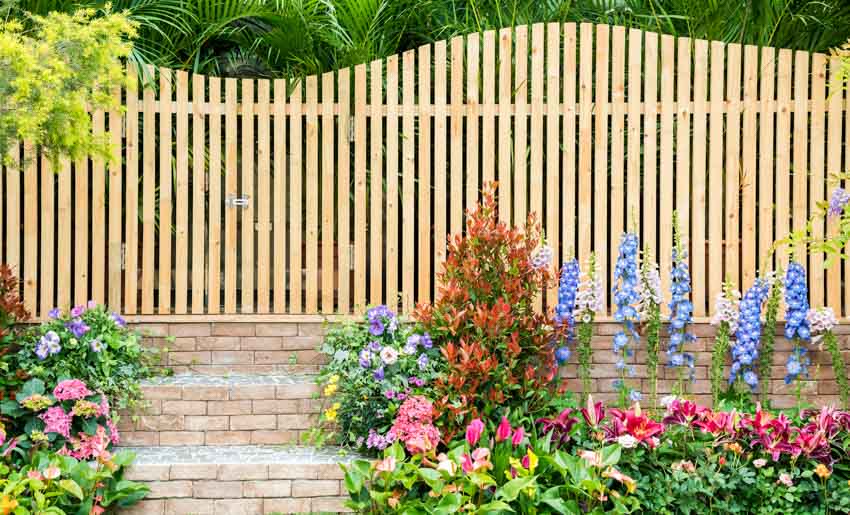 Backyard with retaining wall, plants, and flowers