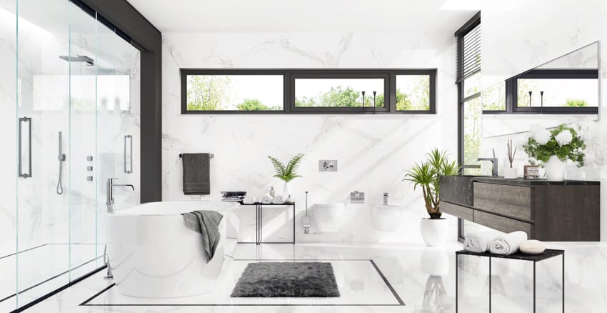 Bathroom with bookmatched porcelain wall, tub, glass door, floating vanity, toilet, and windows