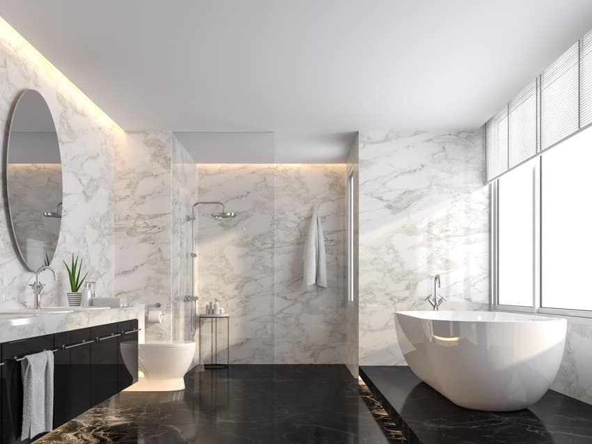 Bathroom with bookmatched porcelain wall, tub, toilet, floating vanity, mirror, shower area, and windows