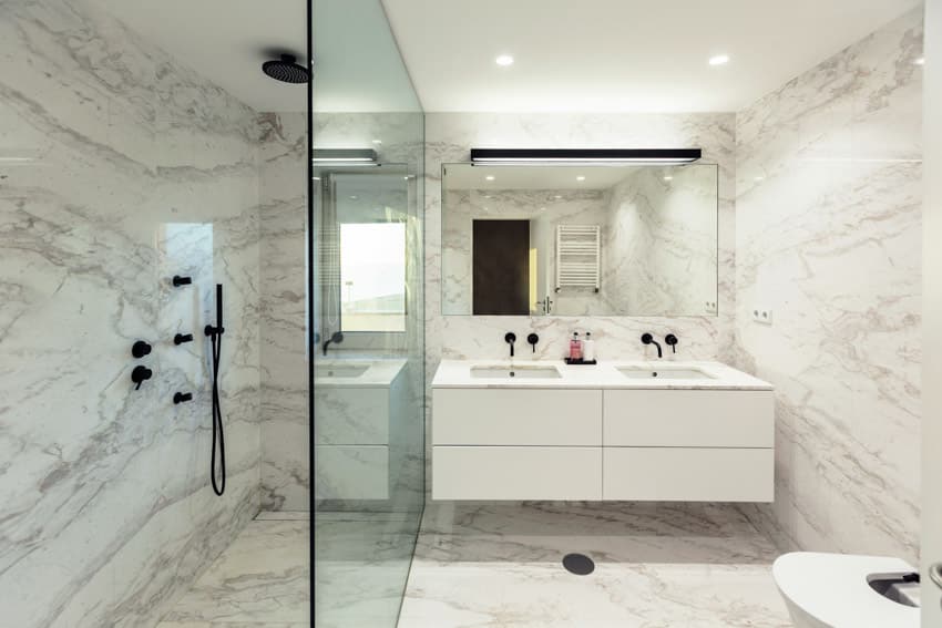 Bathroom with glass divider, shower area, bookmatched porcelain wall, floating vanity, and mirror