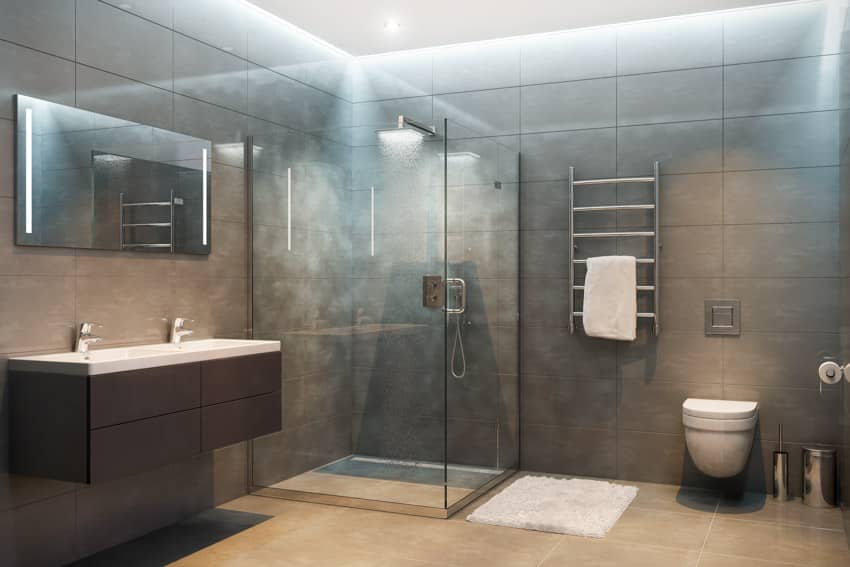 Bathroom with glass shower enclosure, floor to ceiling tiles, floating vanity, mirror, toilet, mirror, and towel holder