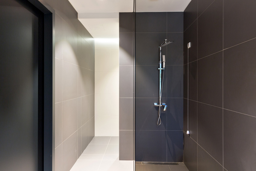 Bathroom with large format tile, shower walls, glass divider, and shower head