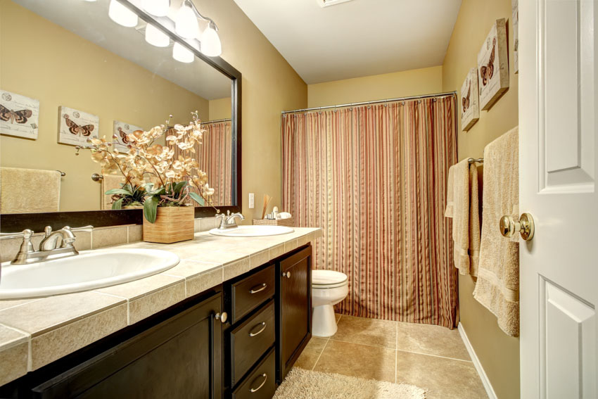 Bathroom with curtain, vanity, drawers, cabinet, countertop, mirror, and toilet