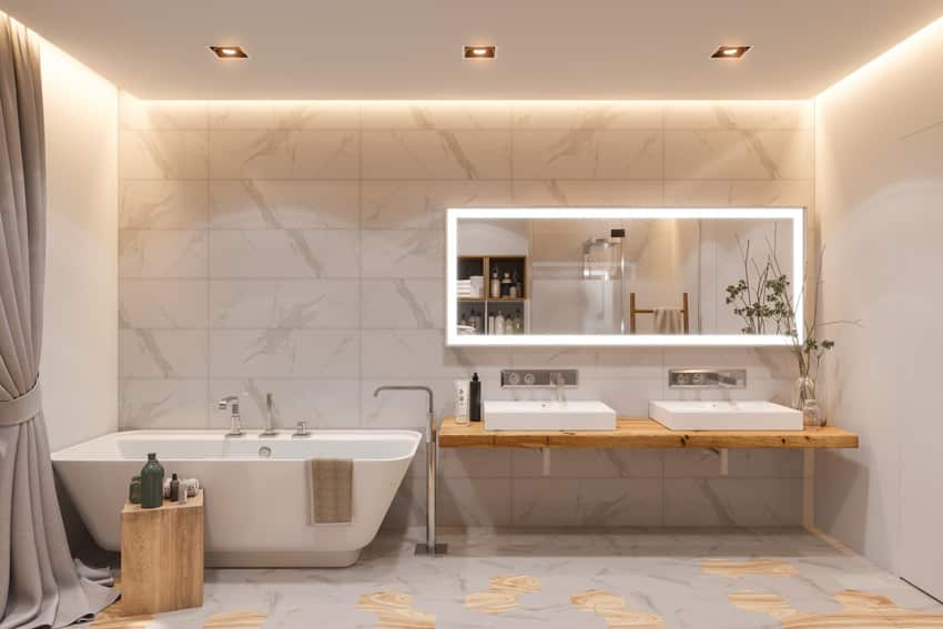 Bathroom with Statuario marble tiles, tub, floating vanity, sinks, mirror, and ceiling lights