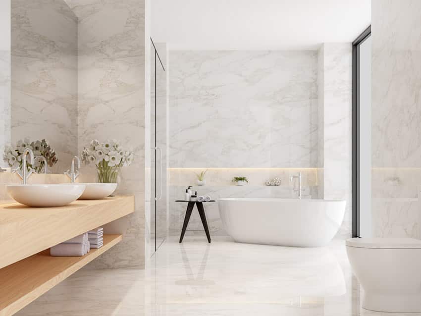 Bathroom with Statuario white marble, tub, floating vanity, sink, and window