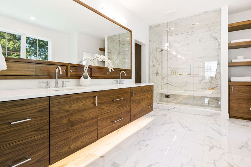 Bathroom with vanity area, shower, wood cabinets, drawers, porcelain floor to ceiling tiles, faucet, and mirror