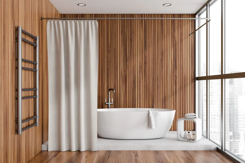 Bathroom with wood slat wall, tub, and curtain