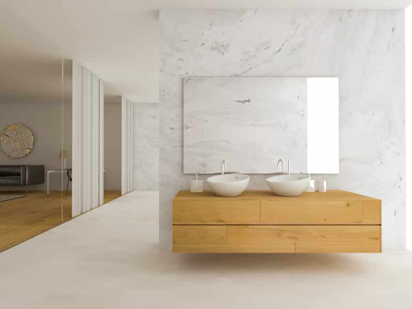 Beautiful bathroom with bookmatched porcelain wall, floating wood vanity, twin basin sinks, and mirror