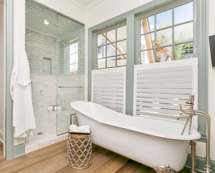 Beautiful bathroom with freestanding bathtub, wooden floors and ceiling shower tile