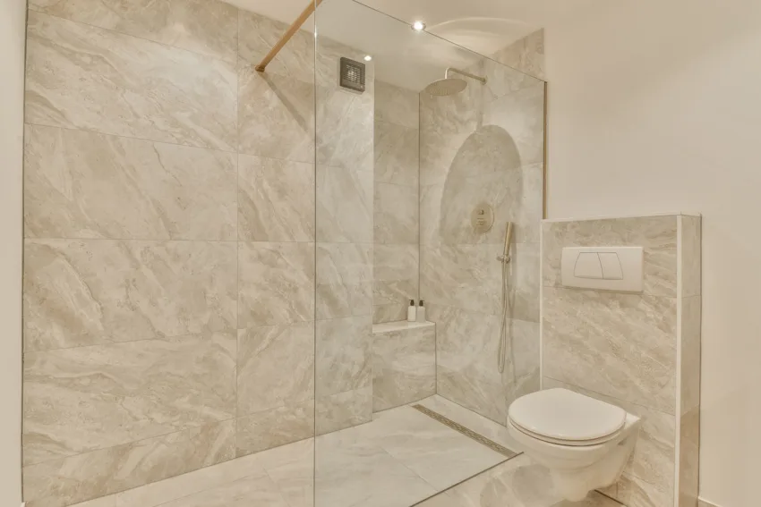 Beautiful bathroom with shower porcelain tiles, framelss divider and toilet 