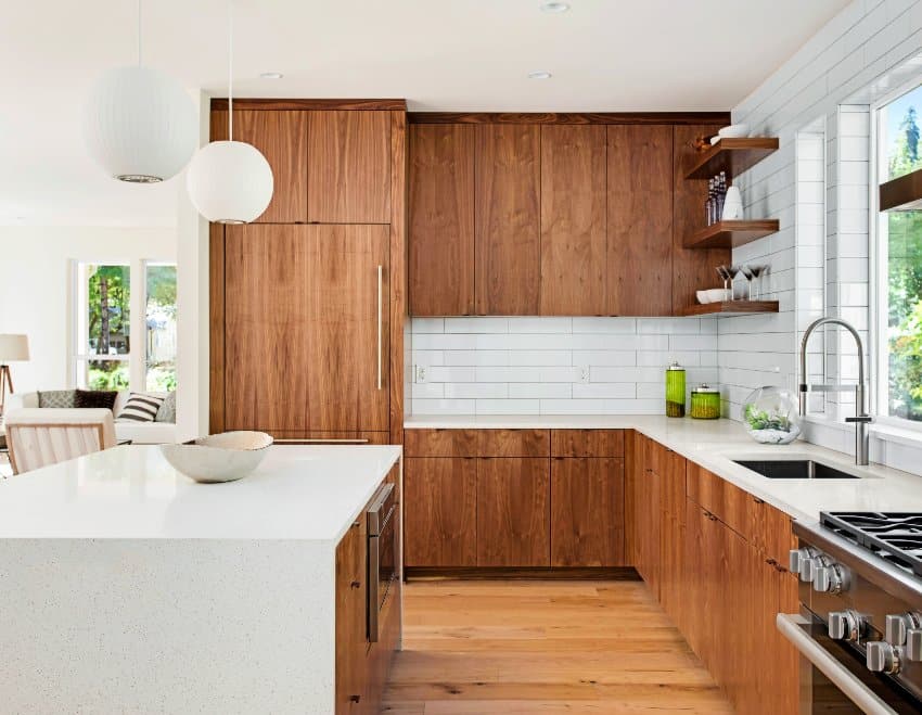 A beautiful kitchen interior with island, pendant lights, shiplap tile backsplash, and hardwood floors