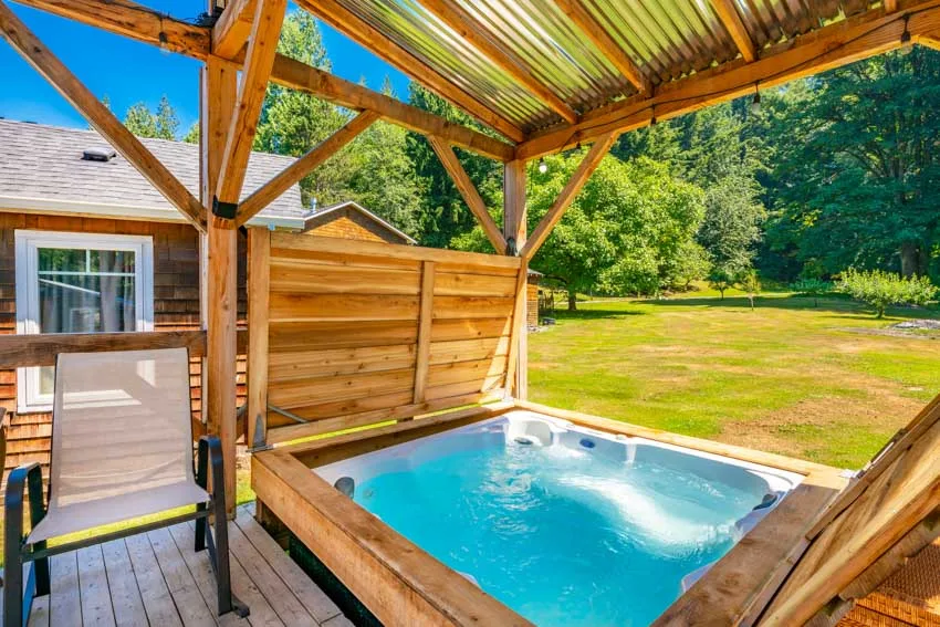 Beautiful outdoor area with wood deck, hot tub, and ozonator