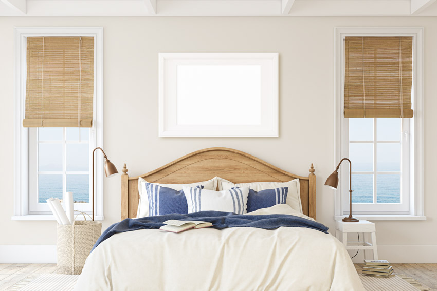 Bedroom with wood Roman shades, bed, headboard, nightstands, twin lamps, pillows, and comforter