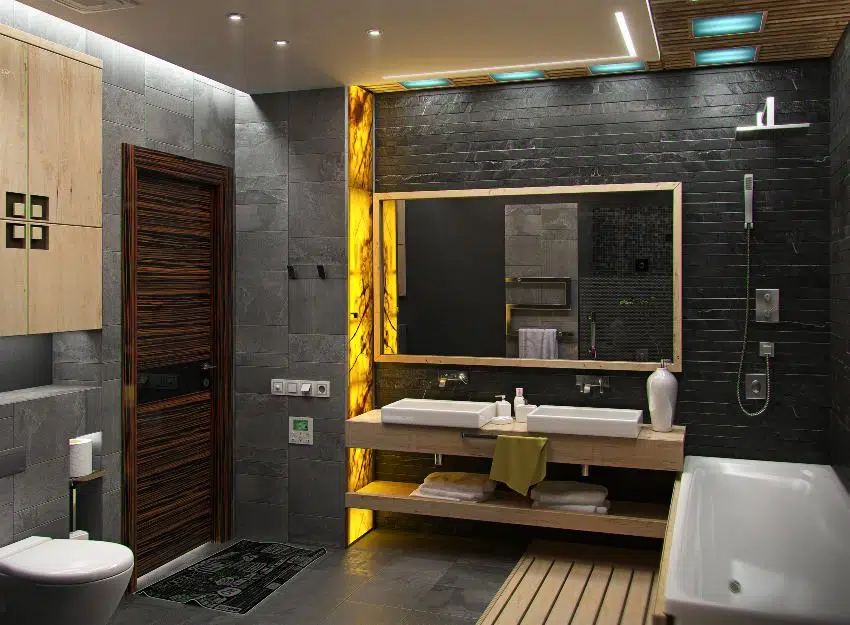 Black modern bathroom interior with yellow light accent on side wall, bathtub, wooden countertop and a toilet 