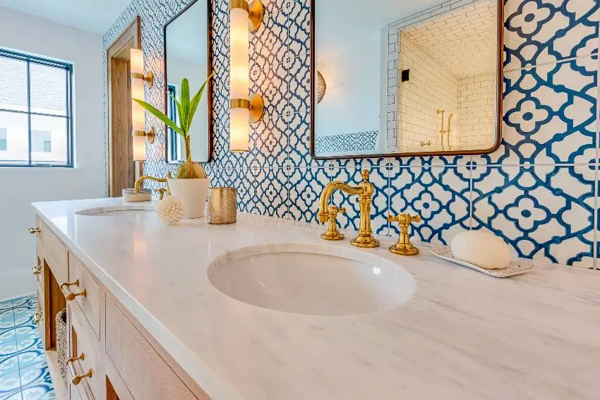 Blue and white patterned tile accent wall in bathroom with natural wood drawers