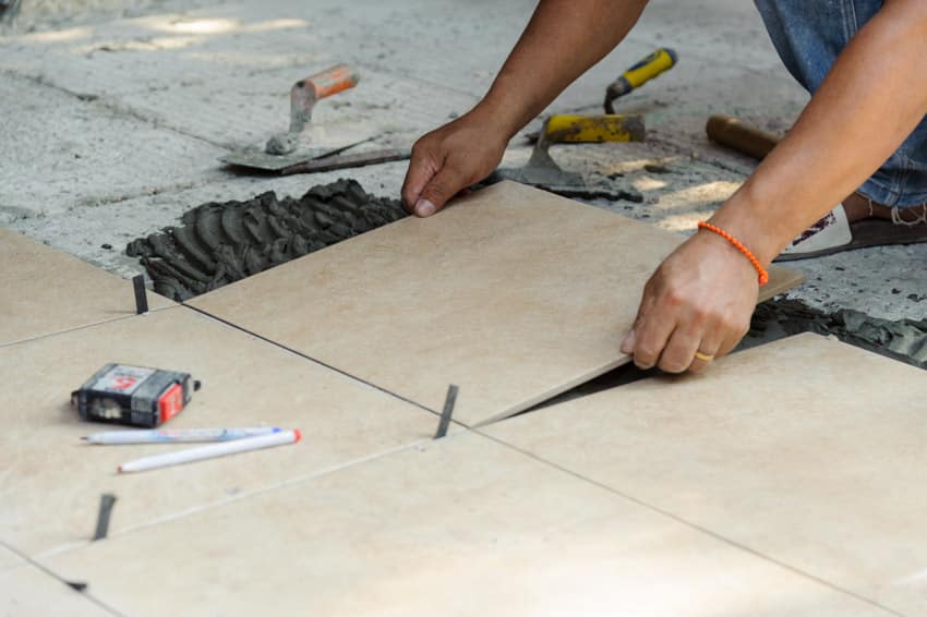 Contractor installing garage porcelain floor tiles