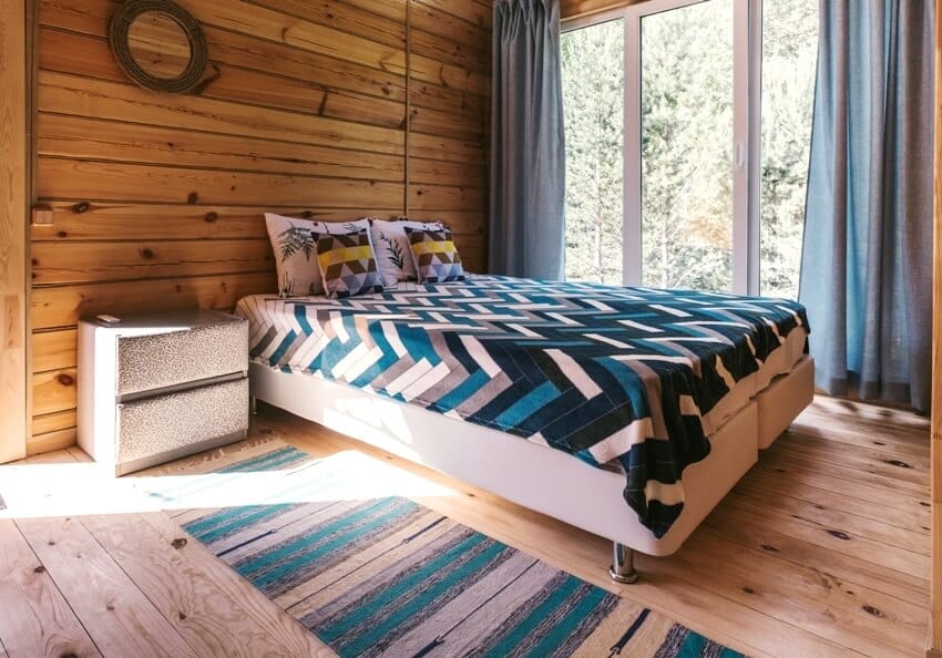 A cozy wooden bedroom interior with pine wood floors and walls